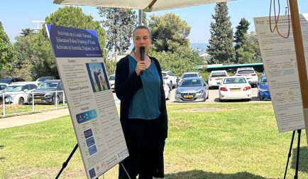 Woman presenting her poster, staying on grass